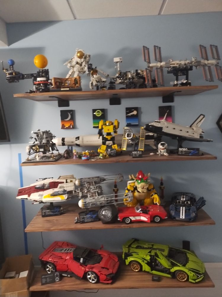 Shelves full of assembled LEGO sets, mostly space, cars, and start wars sets