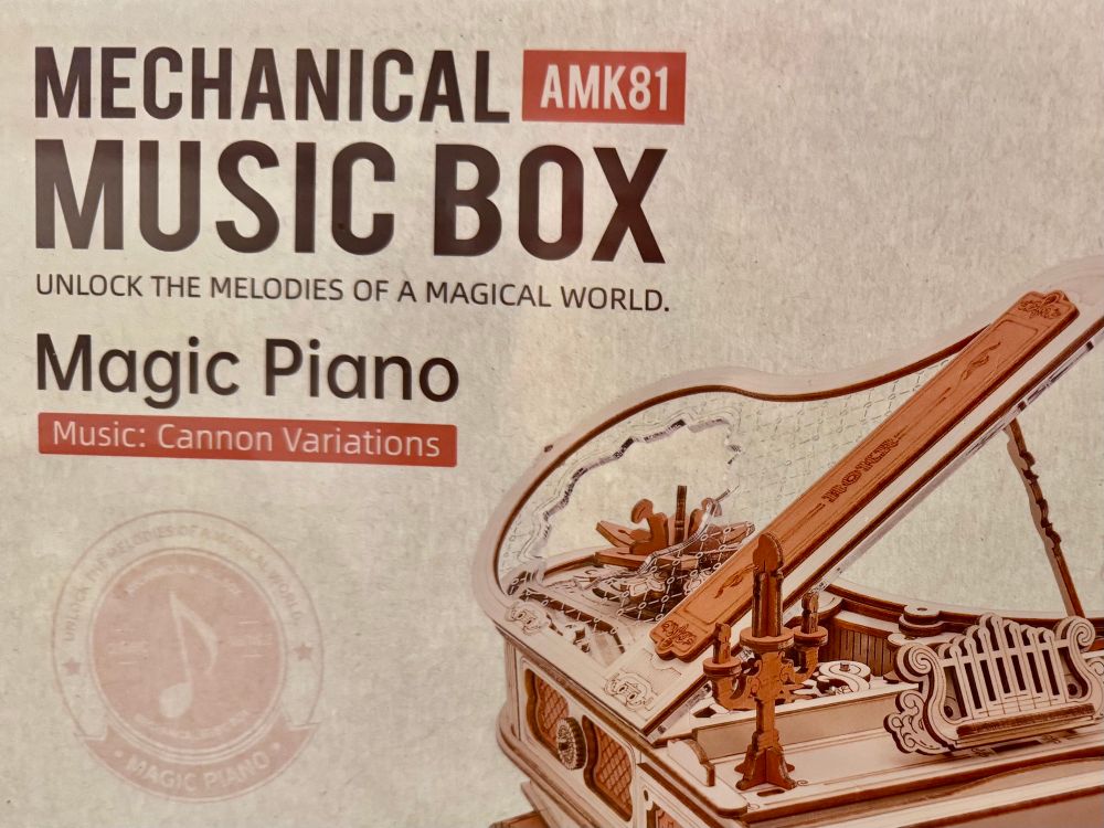 A “mechanical music box” kit that makes a wooden music box shaped like a piano. It says on the box, “Music: Cannon Variations”