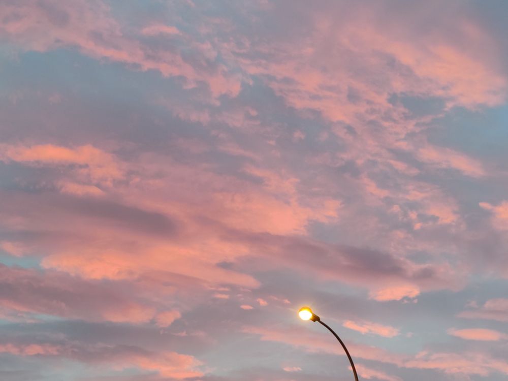 Ciel nuageux au coucher du soleil donnant aux nuages des teintes rosées