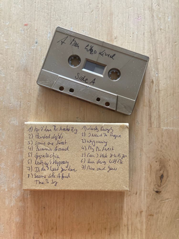 Golden cassette saying “A Man Who Lived” Side A and below a cardboard cassette case revealing the track list.
