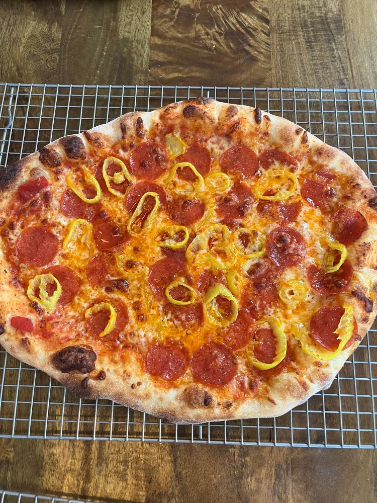 Homemade pizza with pepperoni and banana peppers.