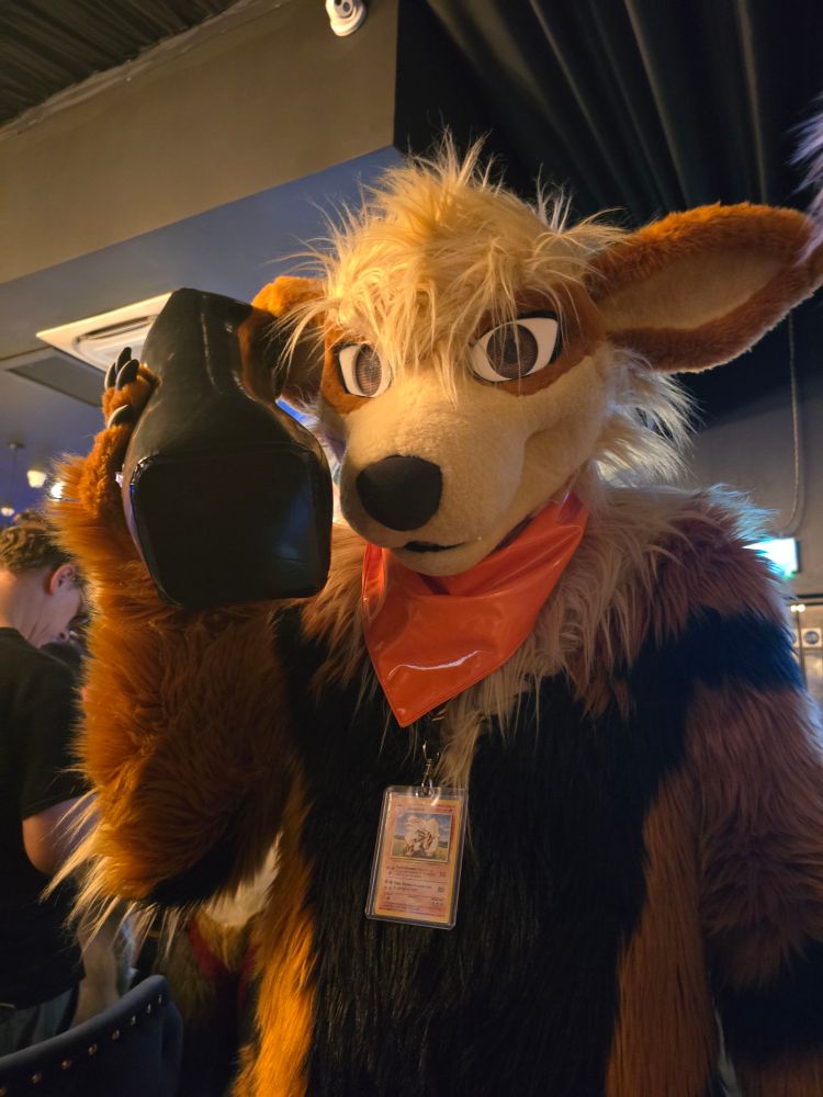 Arcanine fursuiter holding an inflatable Dynatac mobile phone