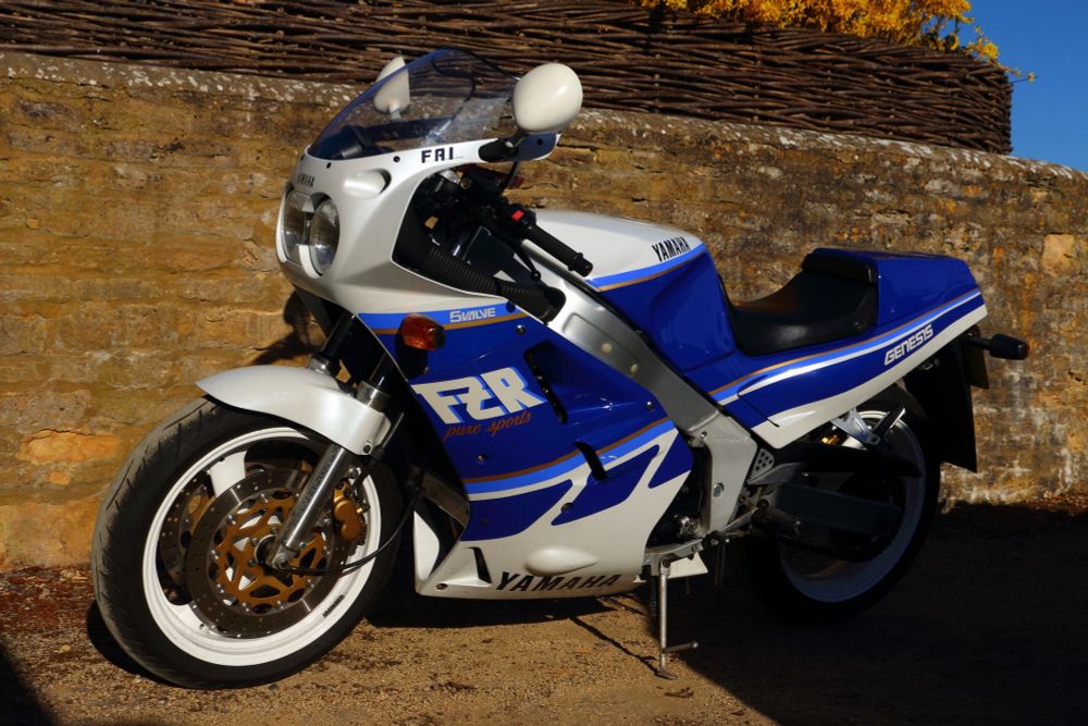 Blue and white 1988 Yamaha FZR1000 Genesis classic motorcycle, sat in the sunshine.