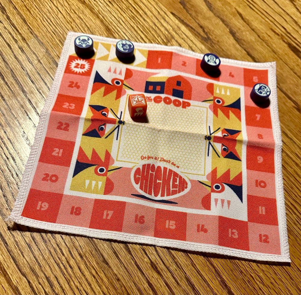 A cloth game board with numbers on the outside pictures on foxes and chickens on it
