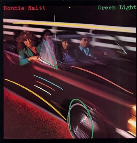 The cover of Bonnie Raitt's album "Green Light," which shows Raitt in the passenger seat of large, maroon convertible, with people who are probably other band members. 