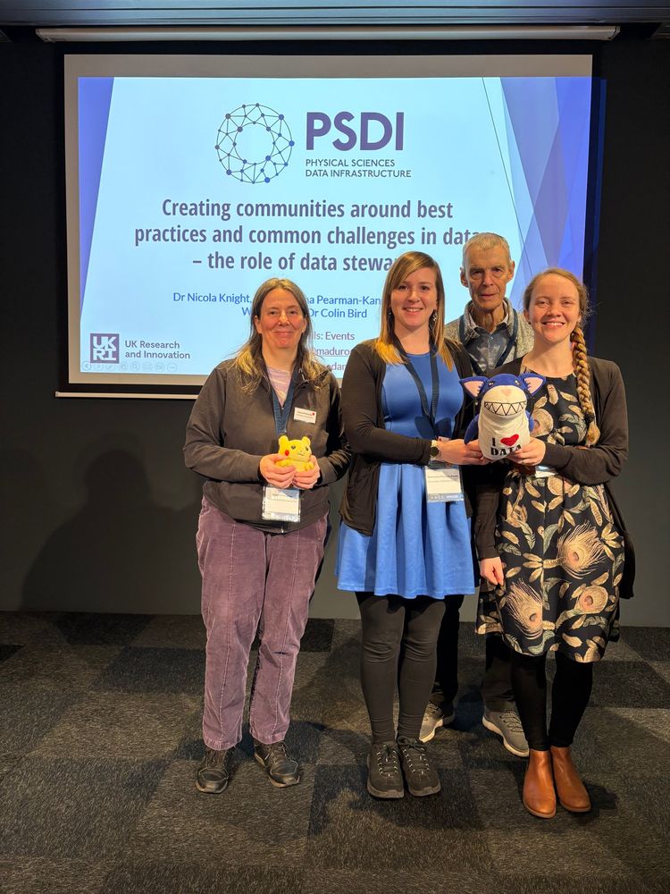 This image shows Cerys Willoughby, Samantha Pearman-Kanza, Colin Bird, Nicola Knight and the PSDI mascot Sharkcat stood in front of the introduction slide for the workshop we are running on "Creating communities around best practices and common challenges in data - the role of data stewards" as part of the International Digital Curation Conference