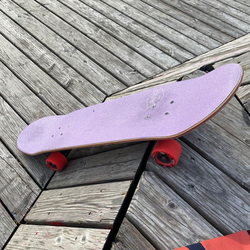 purple skateboard with red wheels