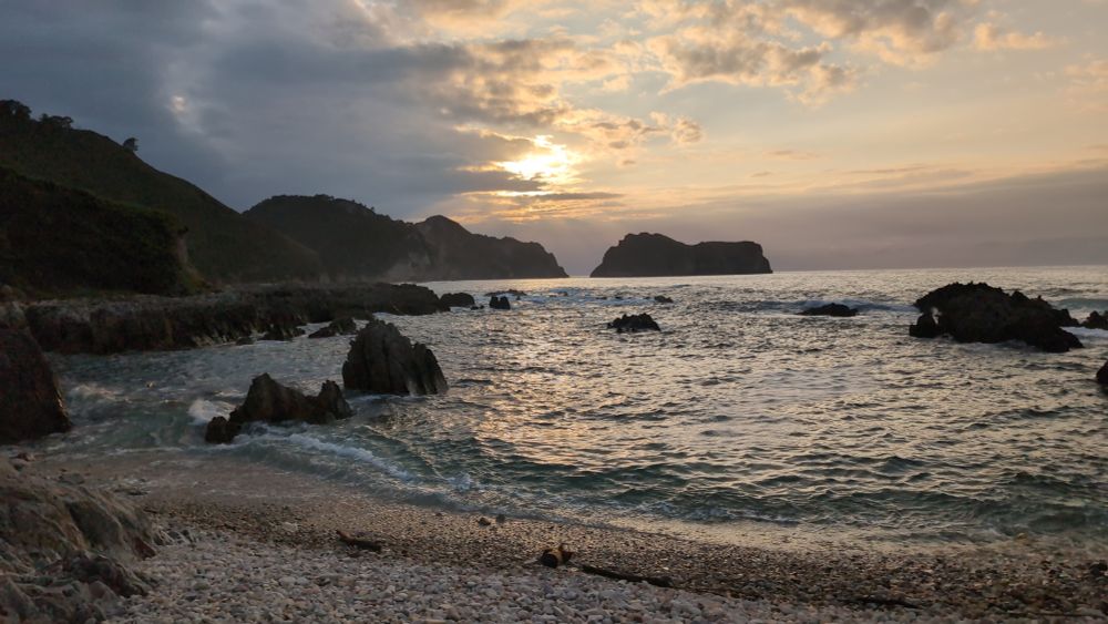 Sonnenuntergang am Meer. Das Meer wird von Klippen durchzogen. Rechts und links ist Steilküste 