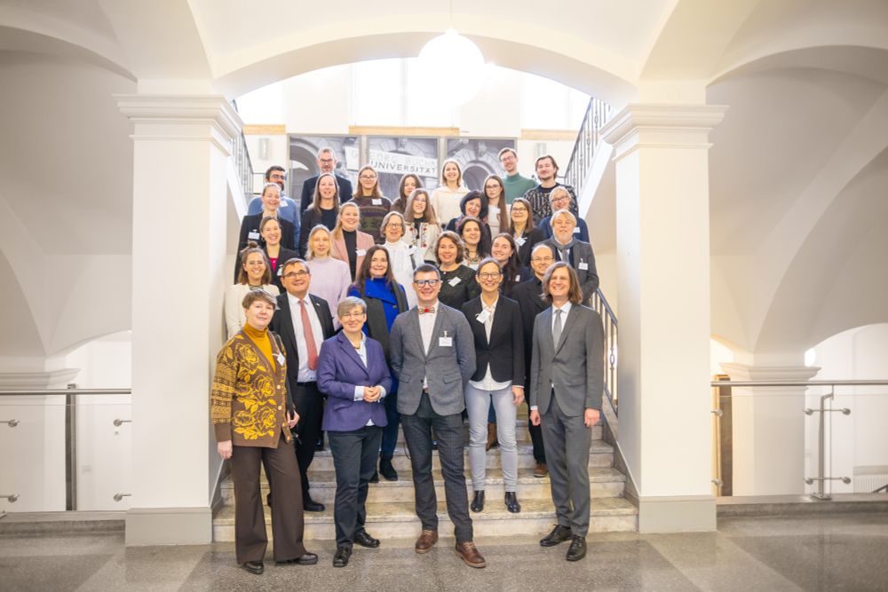 Gäste aus der Ukraine und Gastgeber der JLU positionieren sich in fünf Reihen zum Gruppenbild auf einer Treppe im Uni-Hauptgebäude.