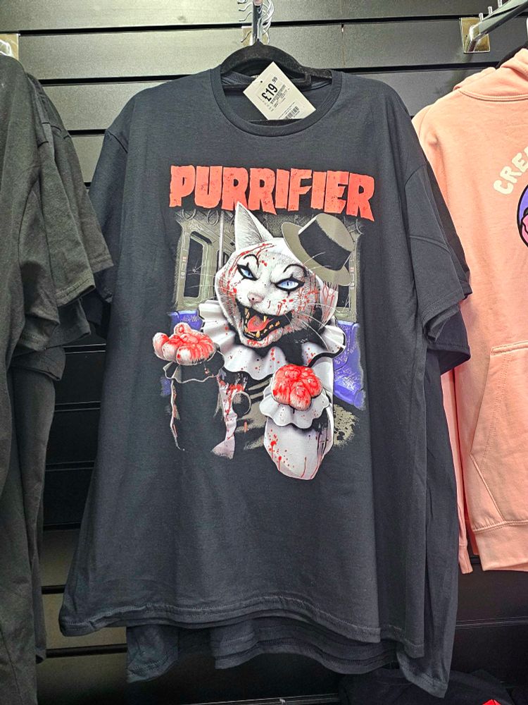 A T-shirt with Art the clown from Terrifier except he's a cat and the title is, "Purrifier". 