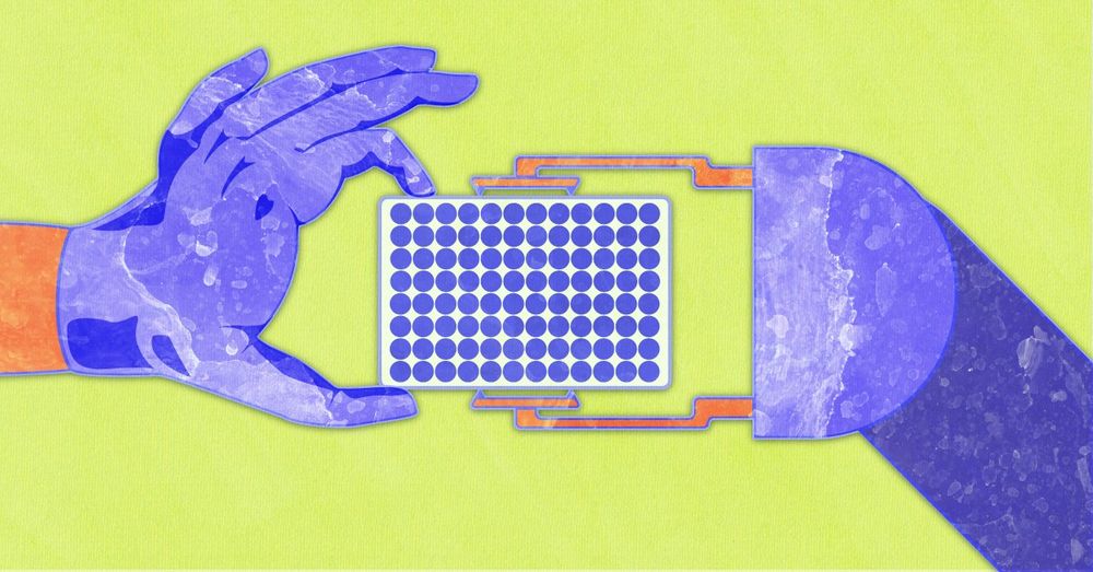 A gloved hand passes a microplate to a lab robot.
