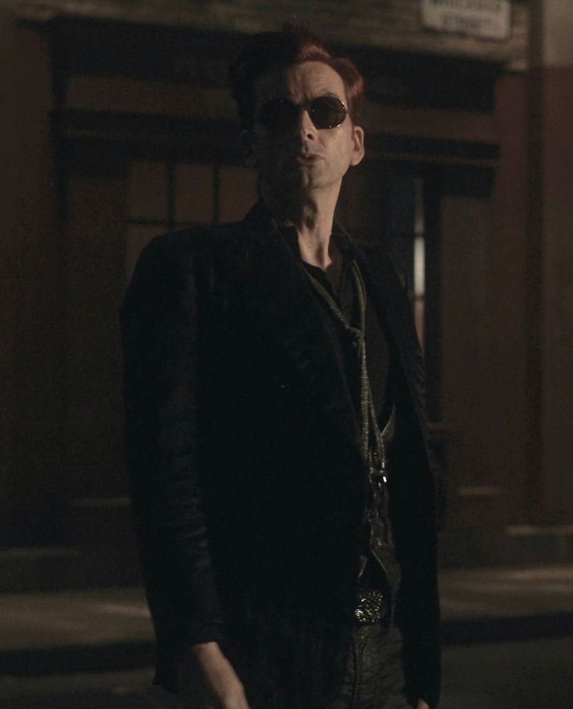 A demon at night, dressed all black wearing sunglasses.
