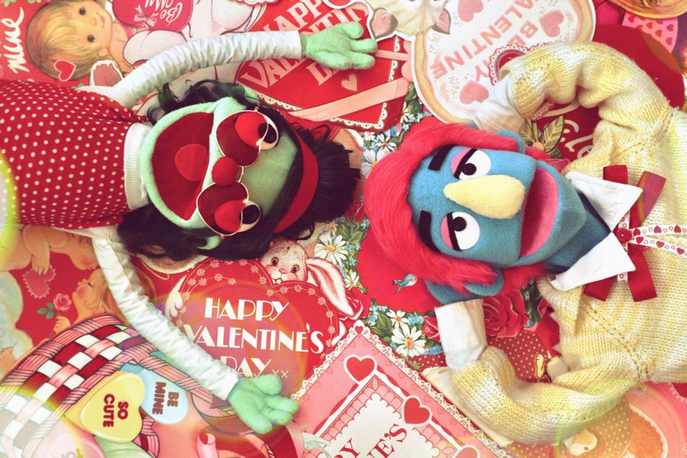 Seamore and Strawbetty the puppets laying on a mountain of valentines cards