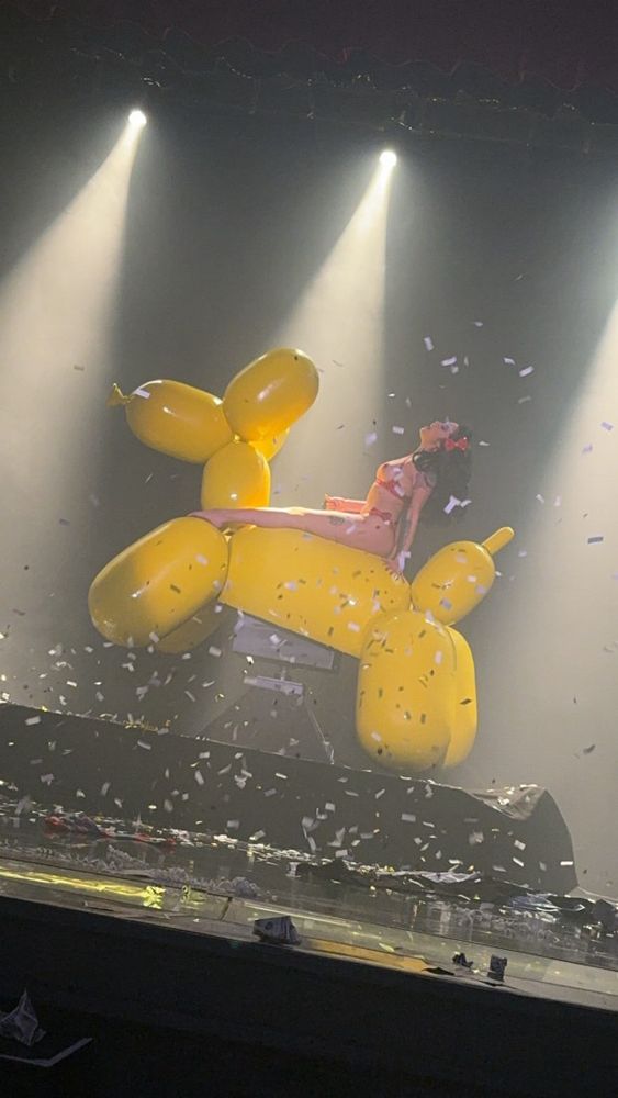 Burlesque clown poses on top of giant mechanical bull, balloon dog. Photo taken during finale of Las Vegas variety show.

