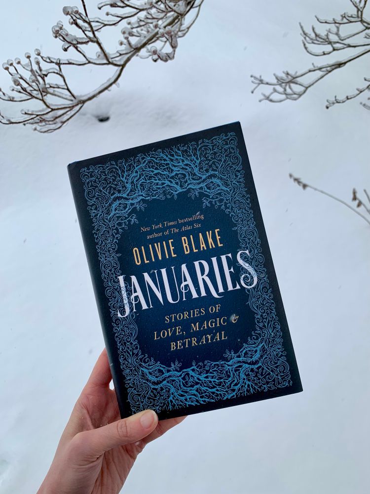 A copy of Olivie Blake’s book Januaries in front of a snowy ground. 