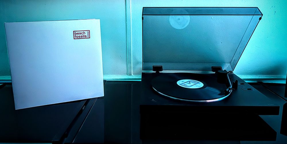 cover of beach fossil's somersault on jacket to left with vinyl spinning on turntable to the right.