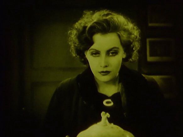 A woman stares into the middle distance with a blank expression. 