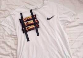 Drei Lions-Schokoriegel sind an einem weißen T-Shirt befestigt. 
(Internetfund)