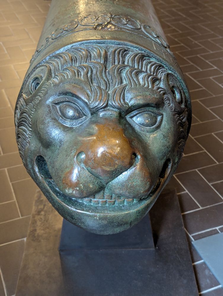 The end of a cannon that's made to be a lion's face