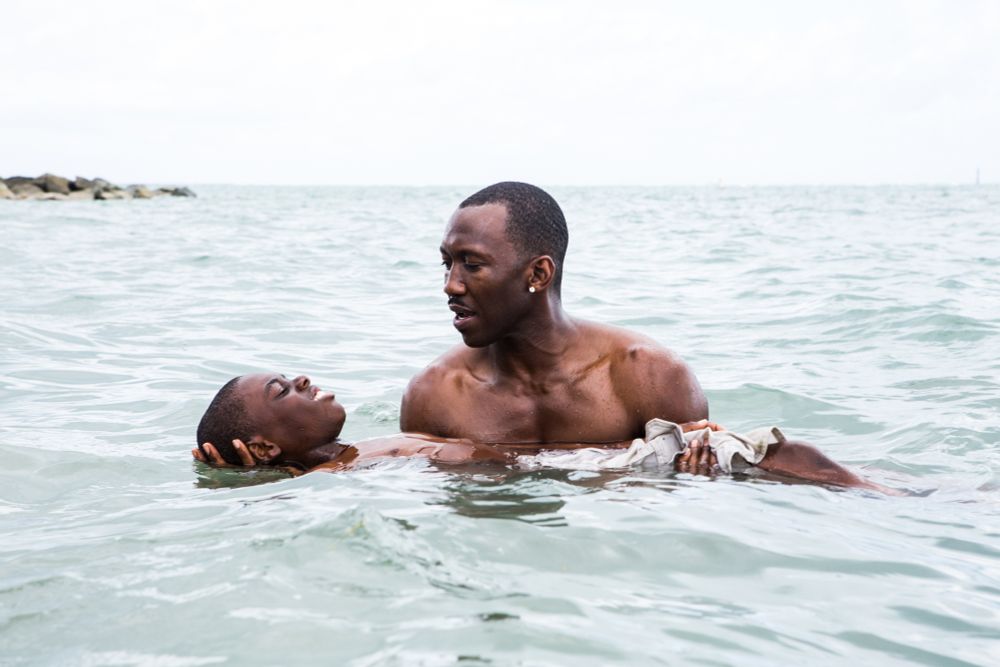 A man teaching a boy to float in water.