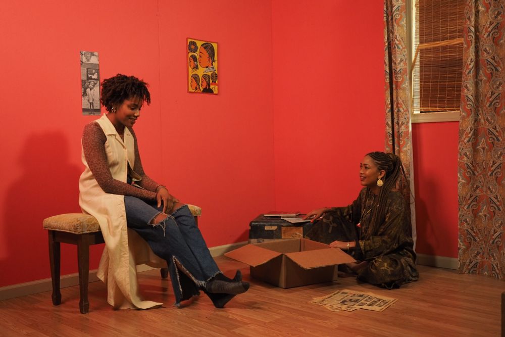 Two women sitting and talking in a living room.