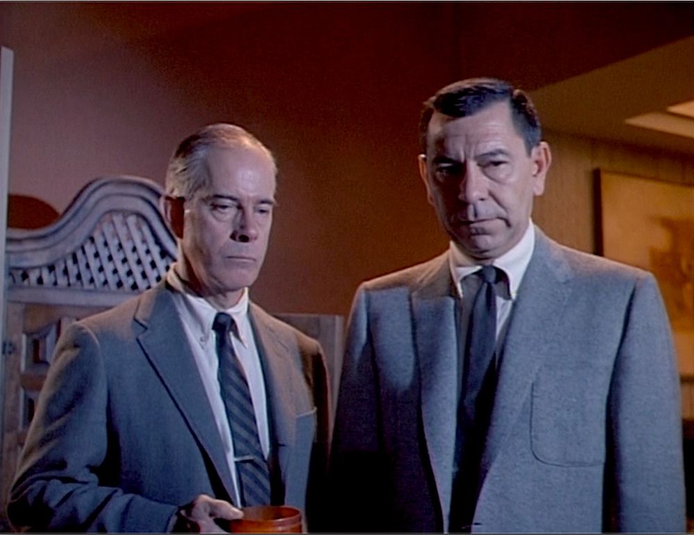 Two stern looking detectives in suits, including actor Jack Webb.