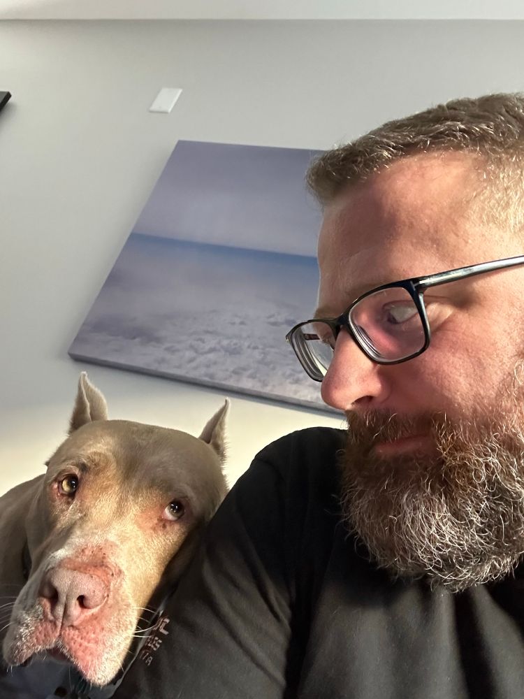 The author and Nala eyeing each other with Nala’s head resting on the author’s right shoulder.