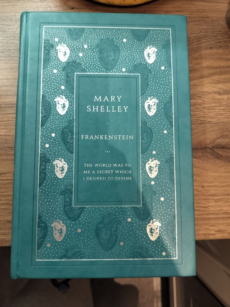 Cover of Frankenstein: a turquoise green hardcover. There are silver hearts placed down the left and right side. In the middle it says 

Mary Shelley 
Frankenstein 
The world was to me a secret which I desired to divine