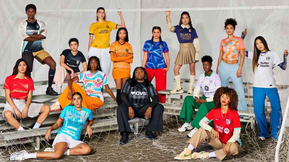 14 Frauen verschiedener Ethnie präsentieren die neuen Trikots. Die Trikots sind bunt.