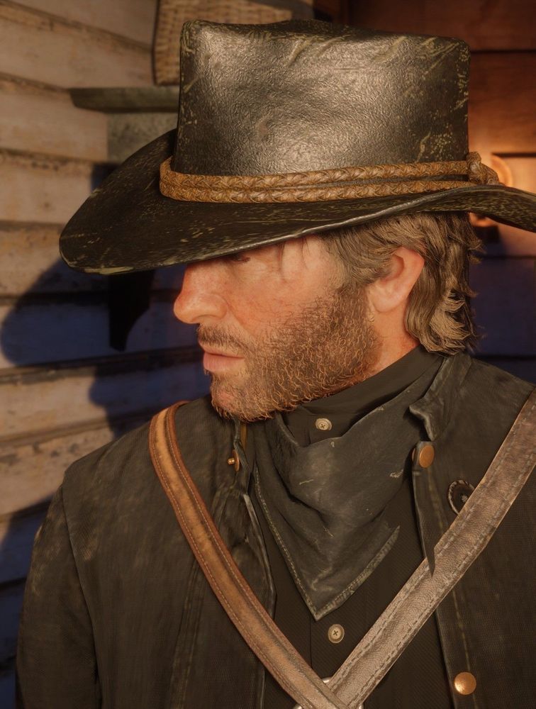 Arthur Morgan of Red Dead Redemption 2 looking off to the side, his cowboy hat obscuring his eyes