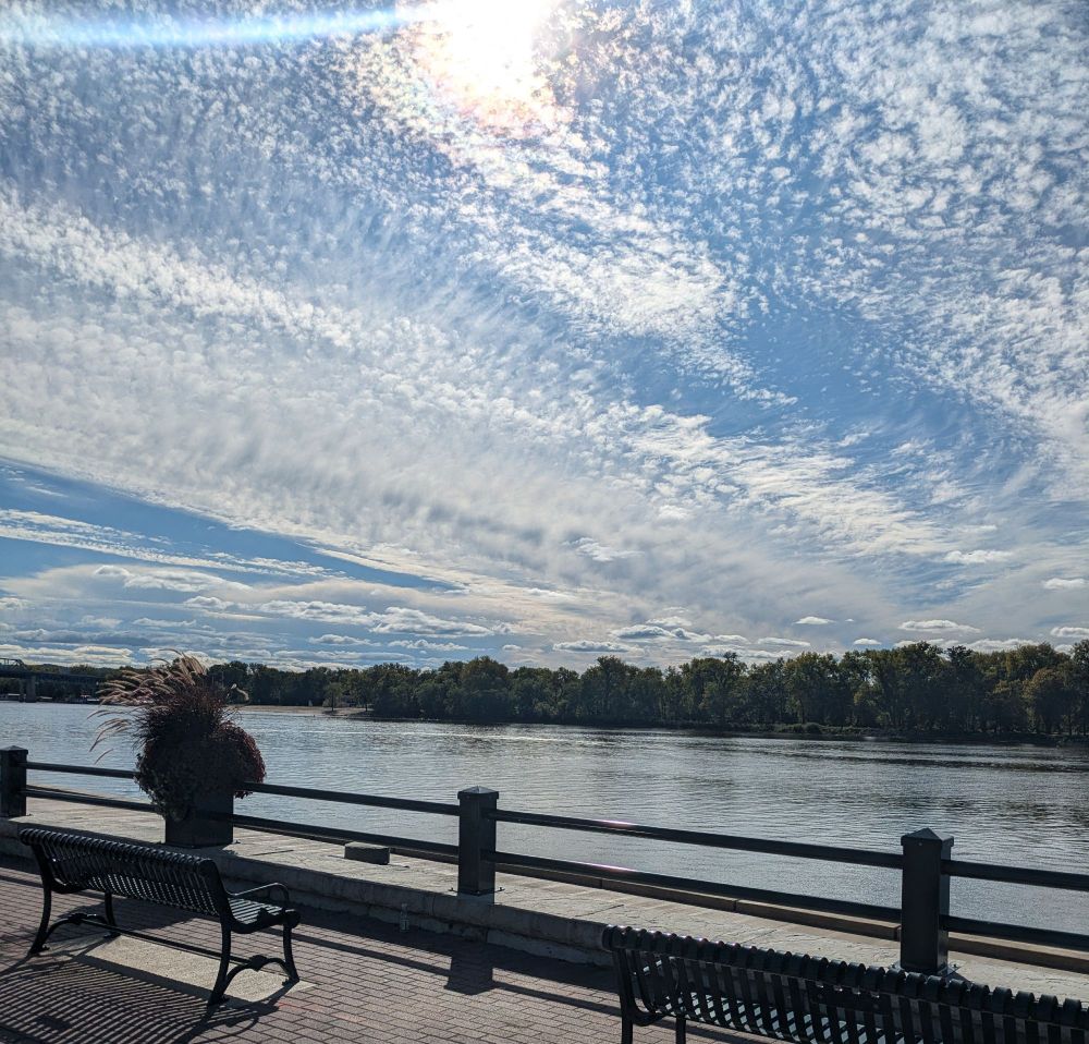 A wider shot of the first scene, showing the sky, Mississippi River and some park benches.