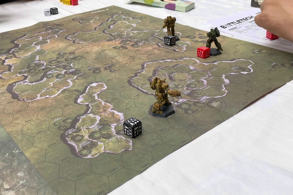 Gaming board with hexes and miniatures of giant robots.
