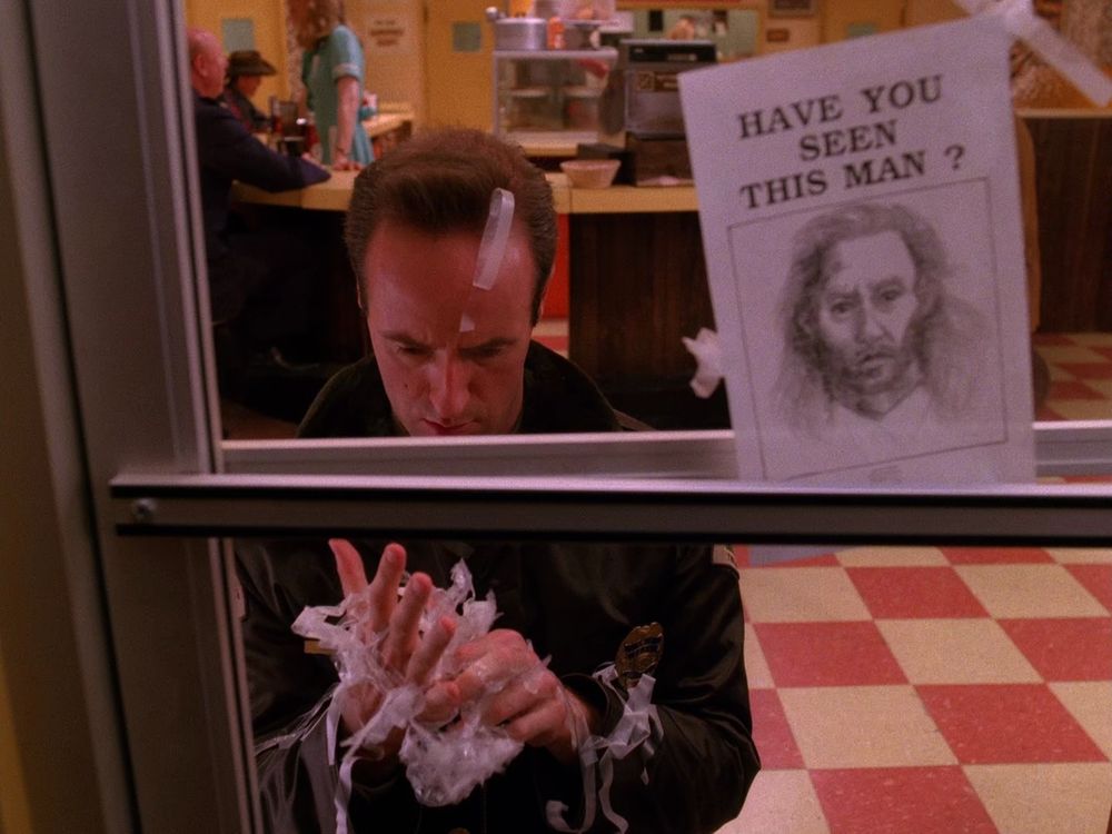 Andy with tape stuck to his hands and face, at the RR diner. Twin Peaks S02E02 - Coma.