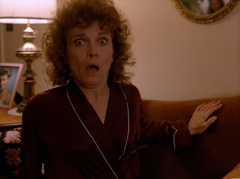Sarah Palmer stares wide-eyed in terror.  (Frank Silva a member of the film crew can be seen in the mirror. This was unintentional and considered a happy accident.  Frank would later go on to play BOB). Twin Peaks S01E01 - Northwest Passage.