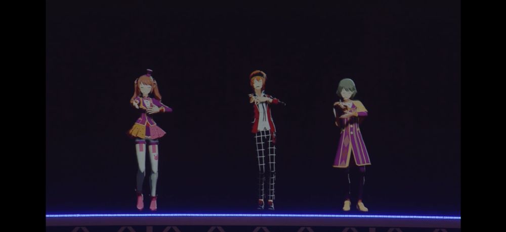 ステージ上でパフォーマンスをする3人。(左から、水嶋咲、若里春名、卯月巻緒)
皆、左手は胸の前、右腕は伸ばして右手を前に出している。

ステージ下部には薄紫色のライトが線状で配置されている。