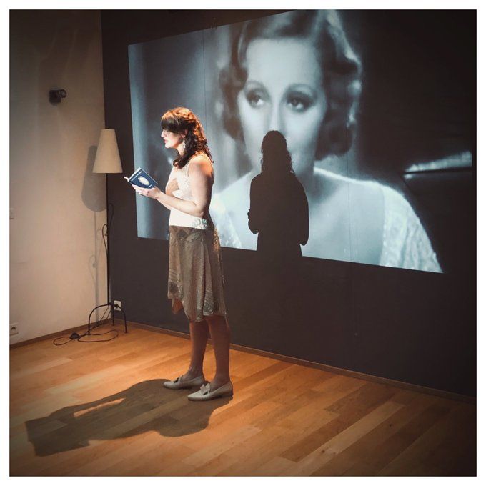 Carrie Chappell performing with a projection of Tallulah Bankhead at the Paris launch party for her poetry collection Loving Tallulah Bankhead