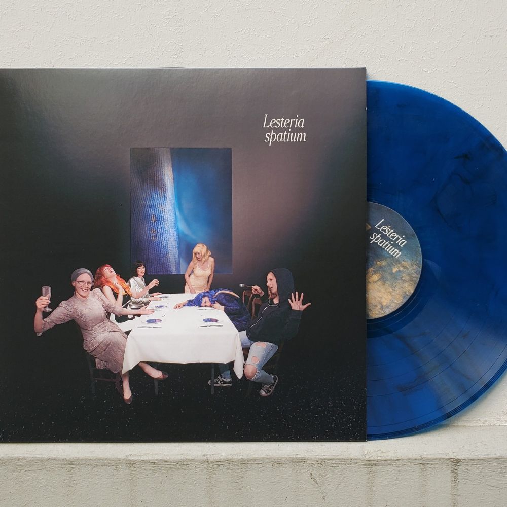 Vinyl edition of Lesteria's album Spatium, with cover art depicting multiple personas of the artist gathered around a dinner table