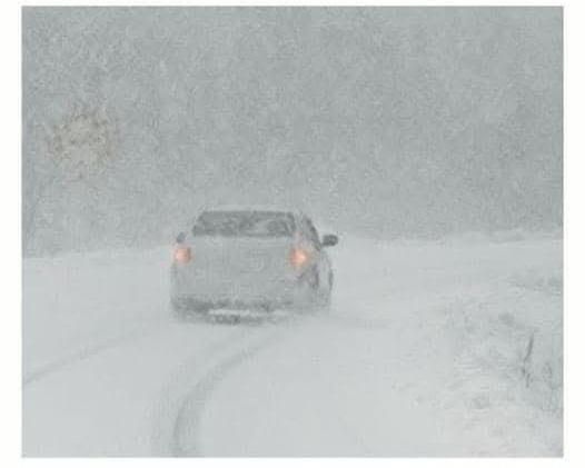 car driving in snow storm
