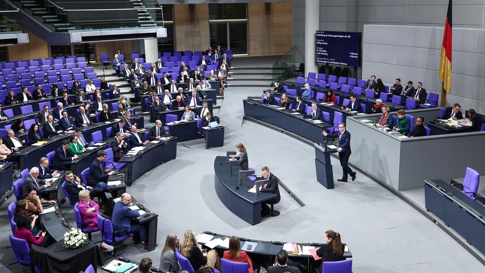 philipp amwürgthor hält eine rede im bundestag, während zahlreiche abgeordnete ihr handy, tablet oder notebook verwenden.