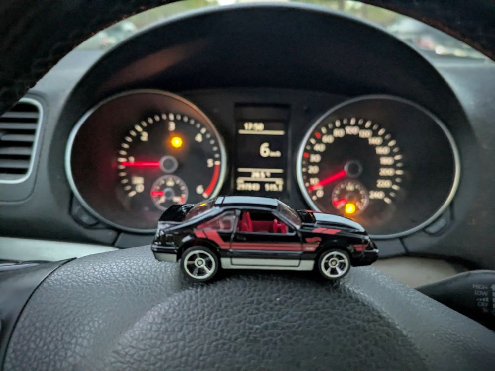 A 92 Ford Mustang Hot Wheels, on the wheel of a 2010 Volkswagen Golf with some warning lights I probably should fix. 