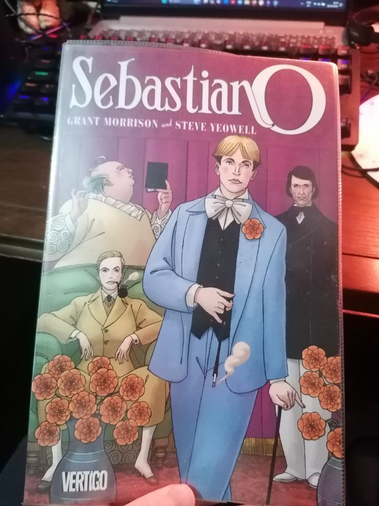 The image shows the books Sebastian O by Grant Morrison and Steve Yeowell, published by Vertigo. The cover shows four figures: one large figure at the back reading a small book; another wearing a suit with a thigh-length overcoat and a bowtie, looking into the camera; a third sits in an armchair with a pipe, wearing a sport-style suit. The final figure stands front and centre, wearing a three-piece suit with a bow-tied cravat and a flower button-hole, hair styled in curtains, smoking a cigarette in a cigarette-holder, and holding a thin walking cane.