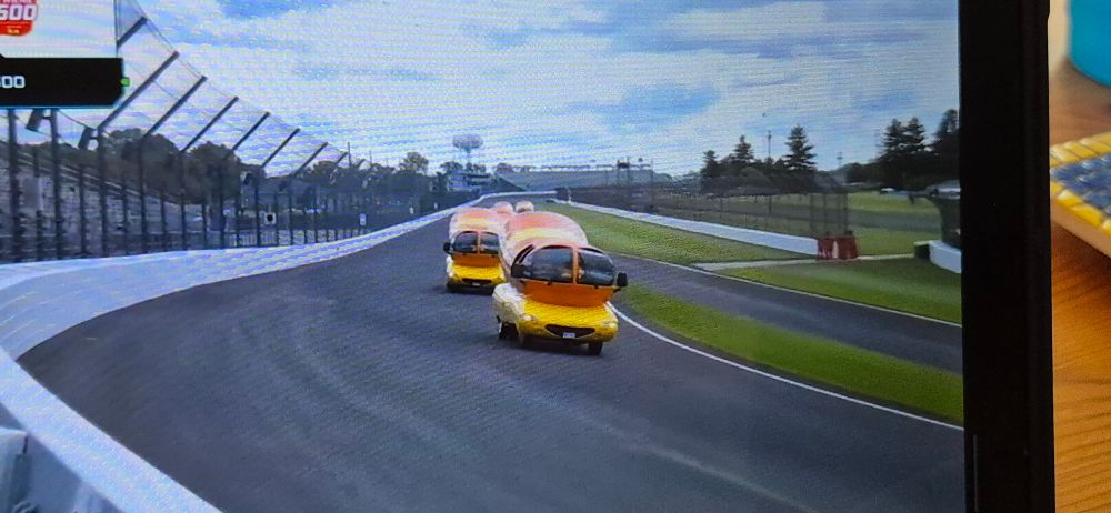 Picture of Oscar Mayer weiner mobiles racing in the Weinie 500 at the Indy 500 raceway