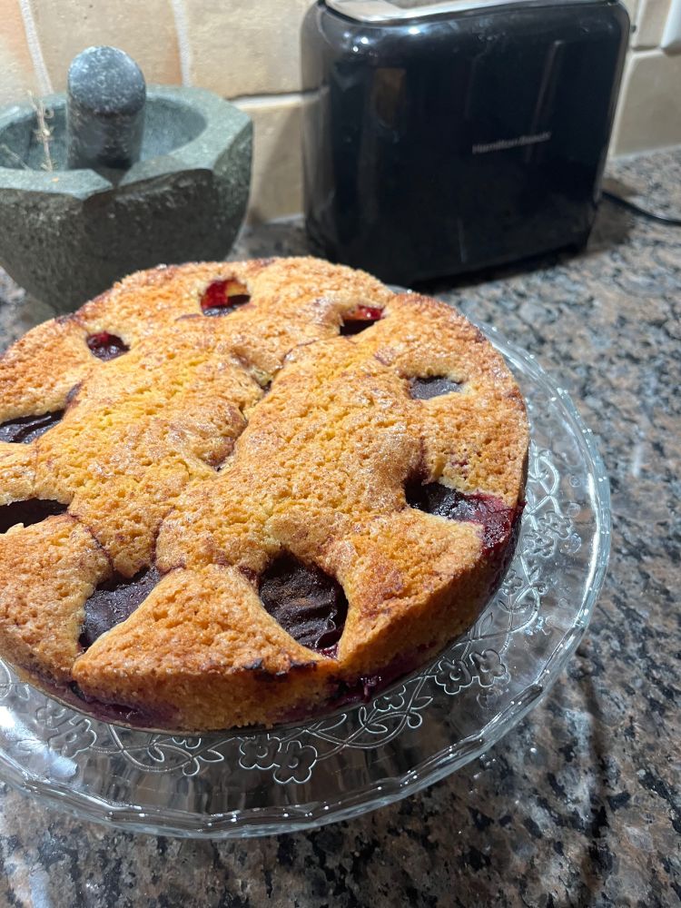 Marion Burros' plum torte on a glass cake stand.