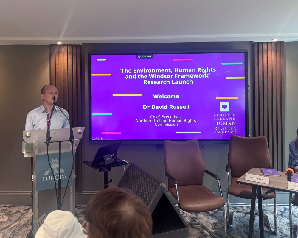 Dr David Russell, Chief Executive of NIHRC, speaking at a podium.