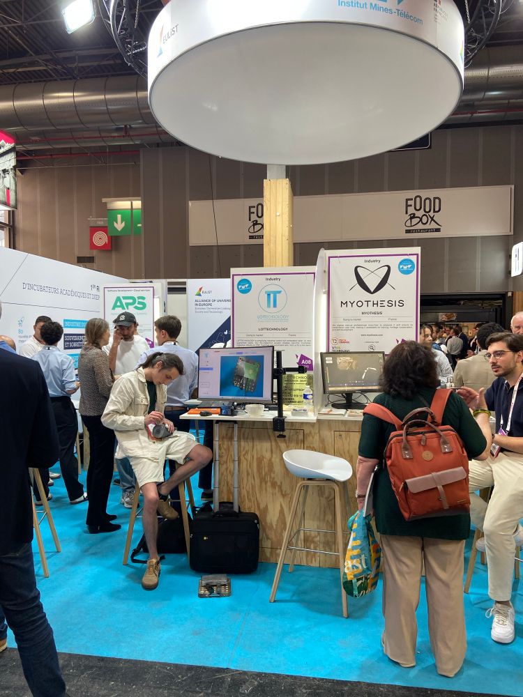 Des personnes discutant sur le stand IMT lors de VivaTech 2025. 