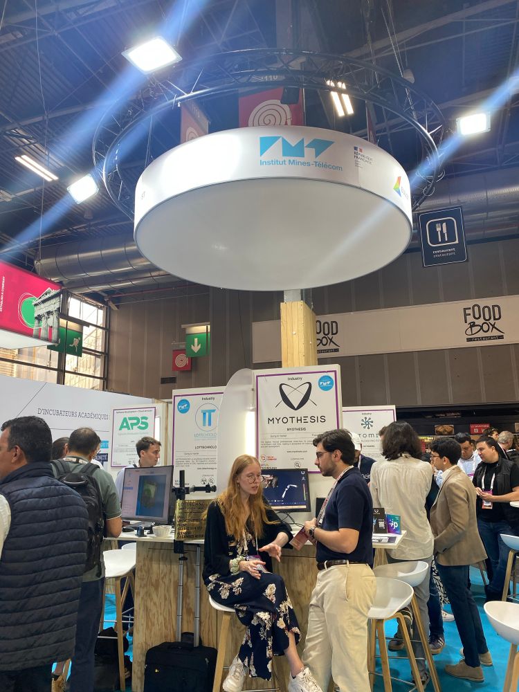 Des personnes discutant sur le stand IMT lors de VivaTech 2025. 