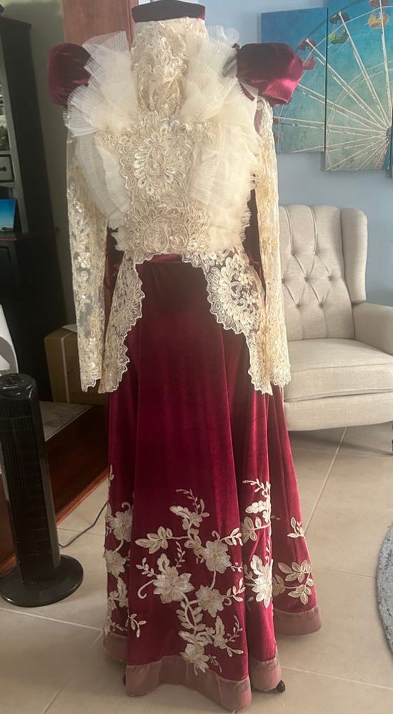 A red velvet dress with white flower lays detail along the hem and a white lace jacket