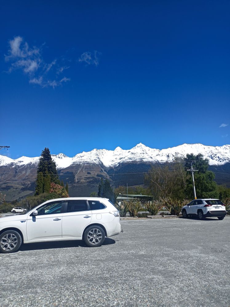 View from a carpark of snow capped mountains on a clear sunny day.