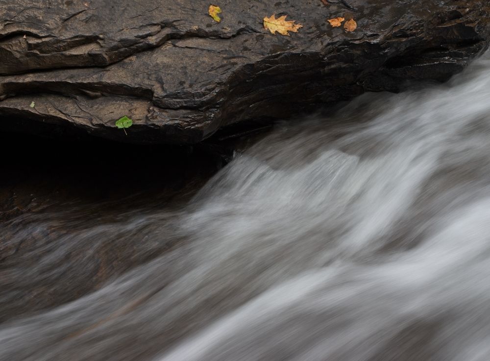a dark rock across the top and flowing water across the bottom