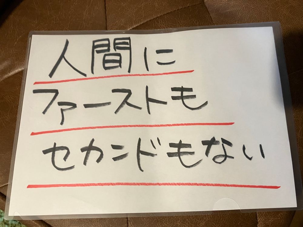 「人間にファーストもセカンドもない」と書かれた紙